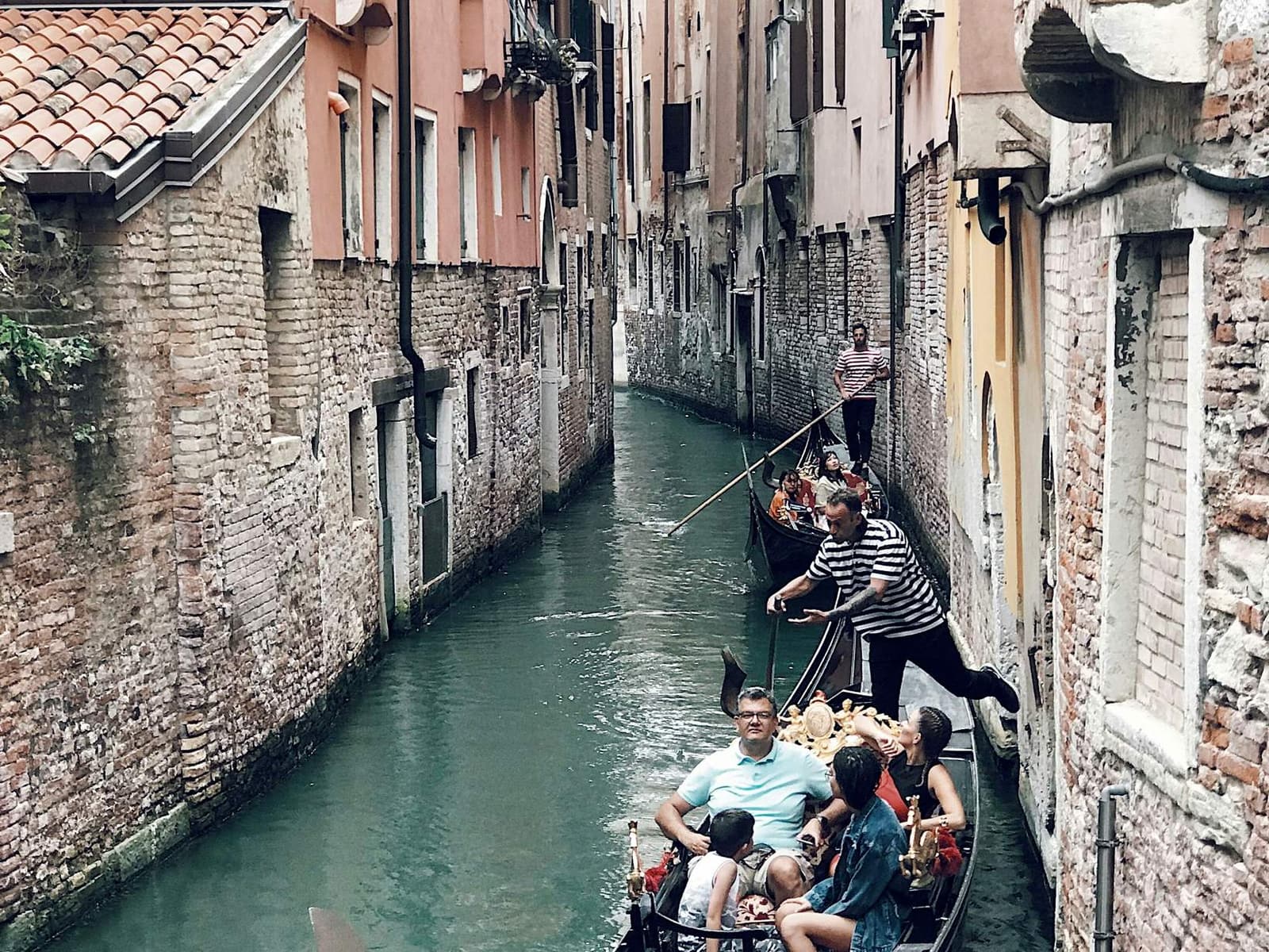 Passengers aboard a gondola on a Venice canal