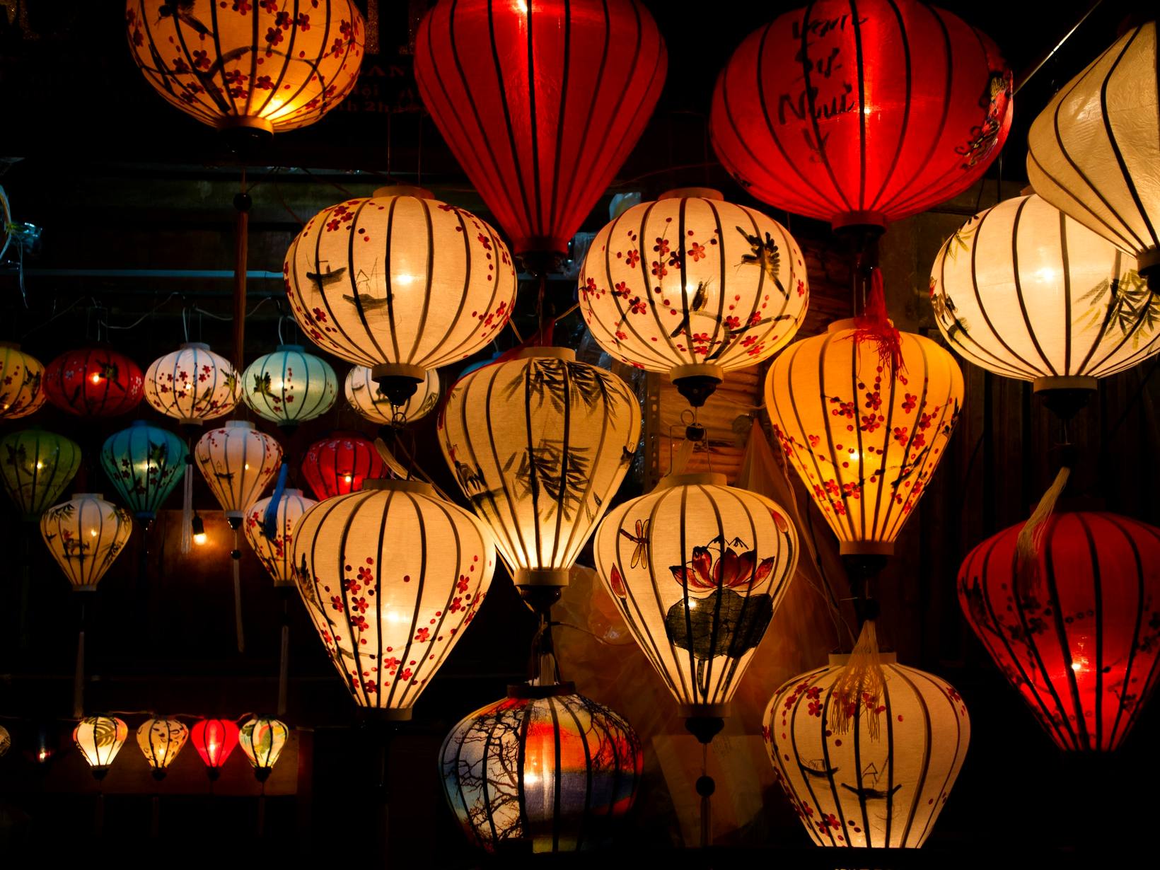 Silk lanterns lit above a Hoi An street at night